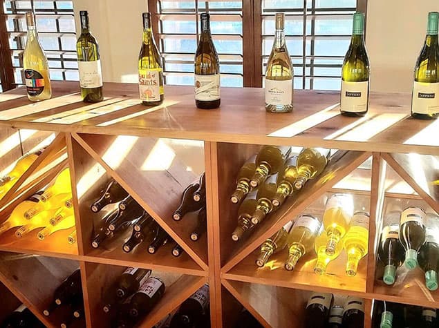 Inside Good Land Wine Shop — sunlit wine bottles on wooden shelves